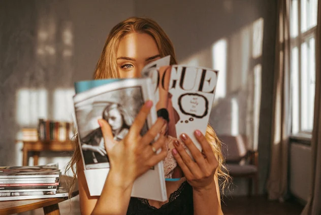 Woman with face partially hidden by magazine, using AI People Search to identify unknown public figures and influencers from photos