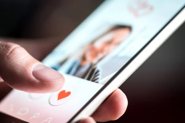 Hand tapping like button on social media, using AI reverse image search to spot catfishing and verify online identities